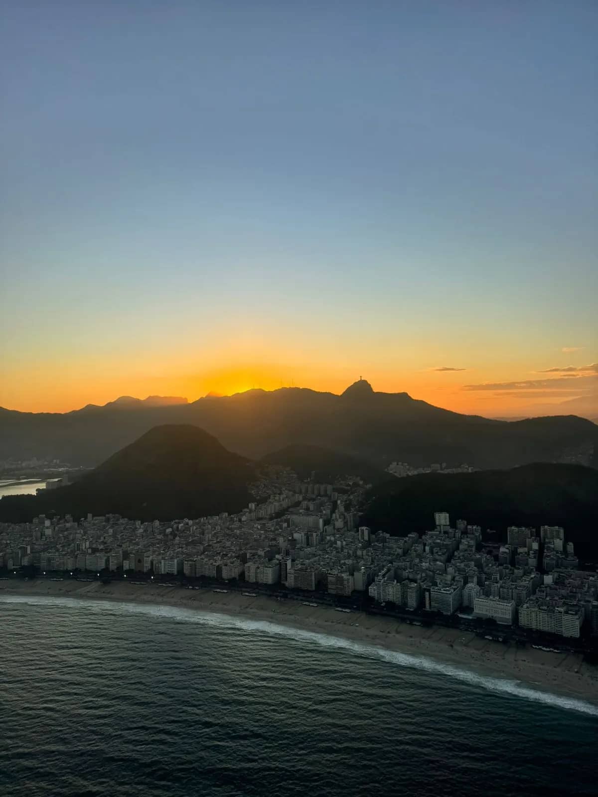 Vista da cabine do helicóptero sobre a Ponte Rio, Niterói ao pôr do sol
